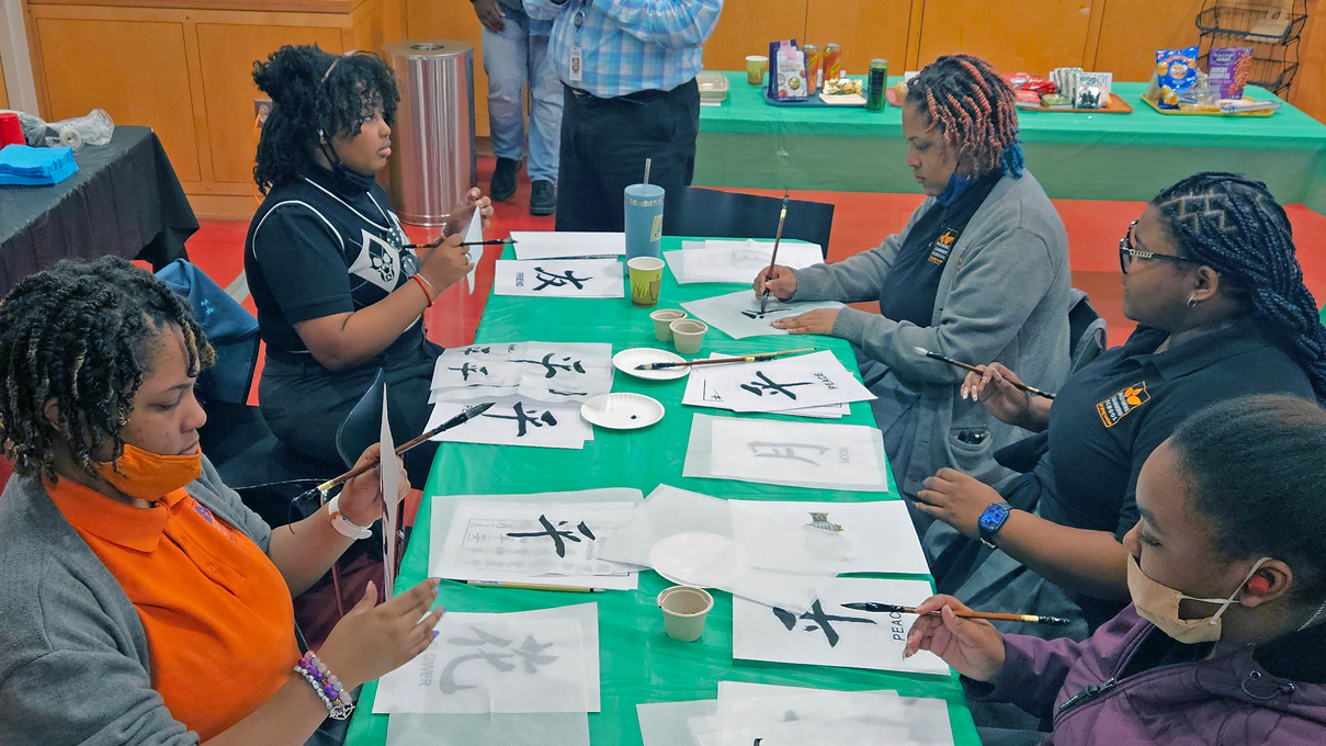 A group of museum visitors making paper art together.